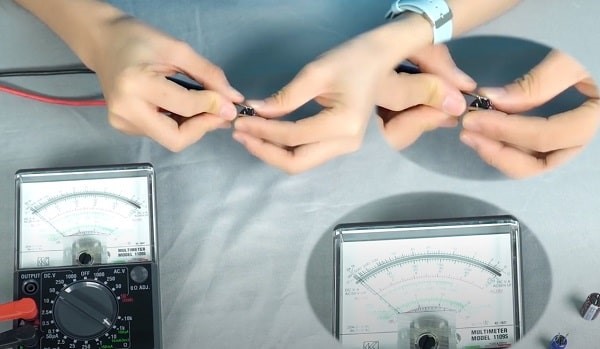 Chạm que đo của đồng hồ vạn năng kim vào 2 cực của tụ điện